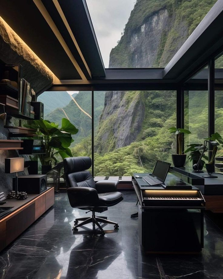 Modern home office with leather chair, desk, and panoramic window overlooking lush green mountains.